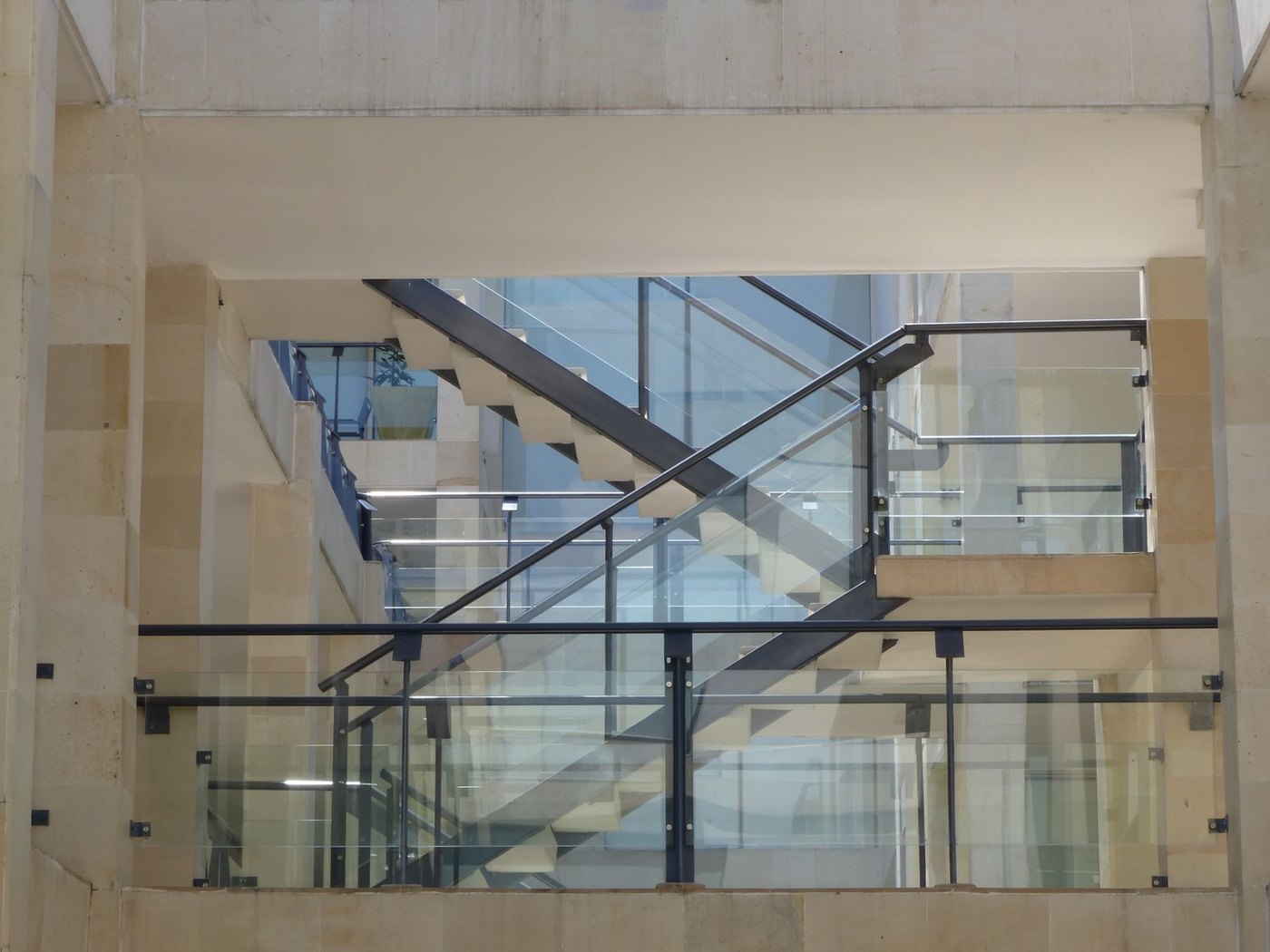 Post-supported glass balustrade on an indoor staircase: transparency with a slim handrail.